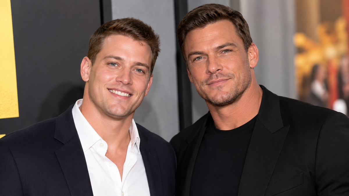 Two adult men in dark jackets posing together at a formal event.