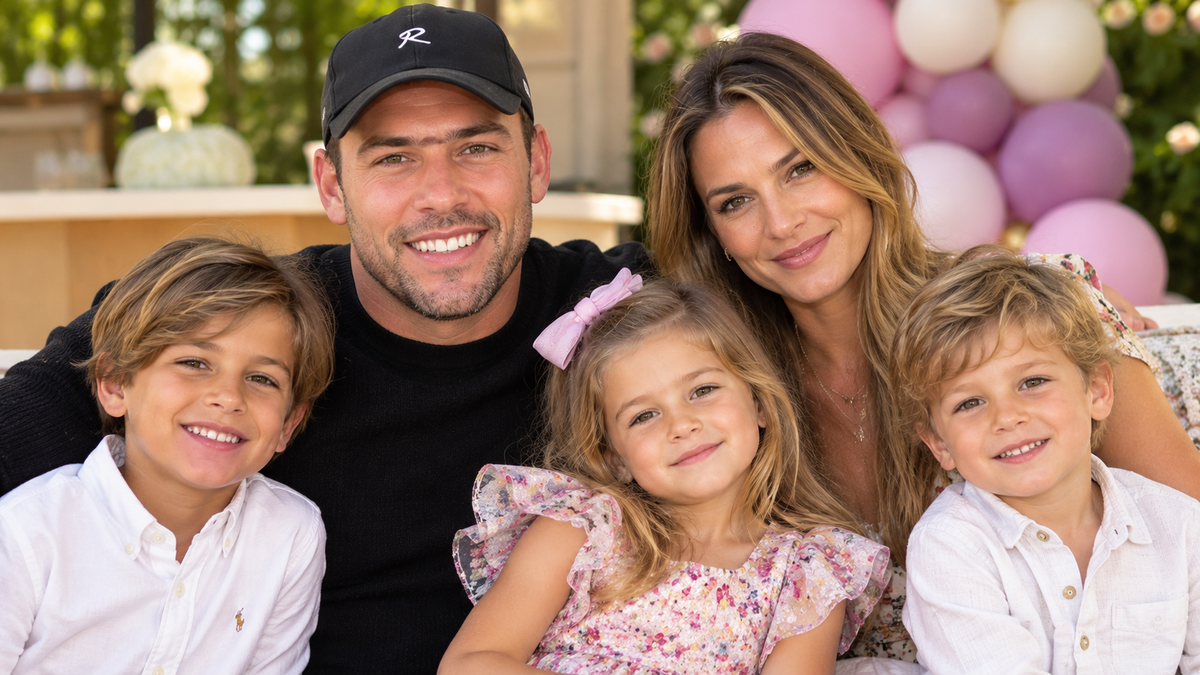 A family of five smiling together at an outdoor celebration.